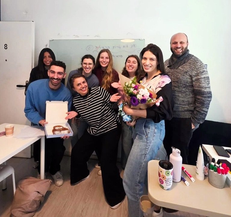Students and teacher celebrating the end of their Hebrew program with flowers